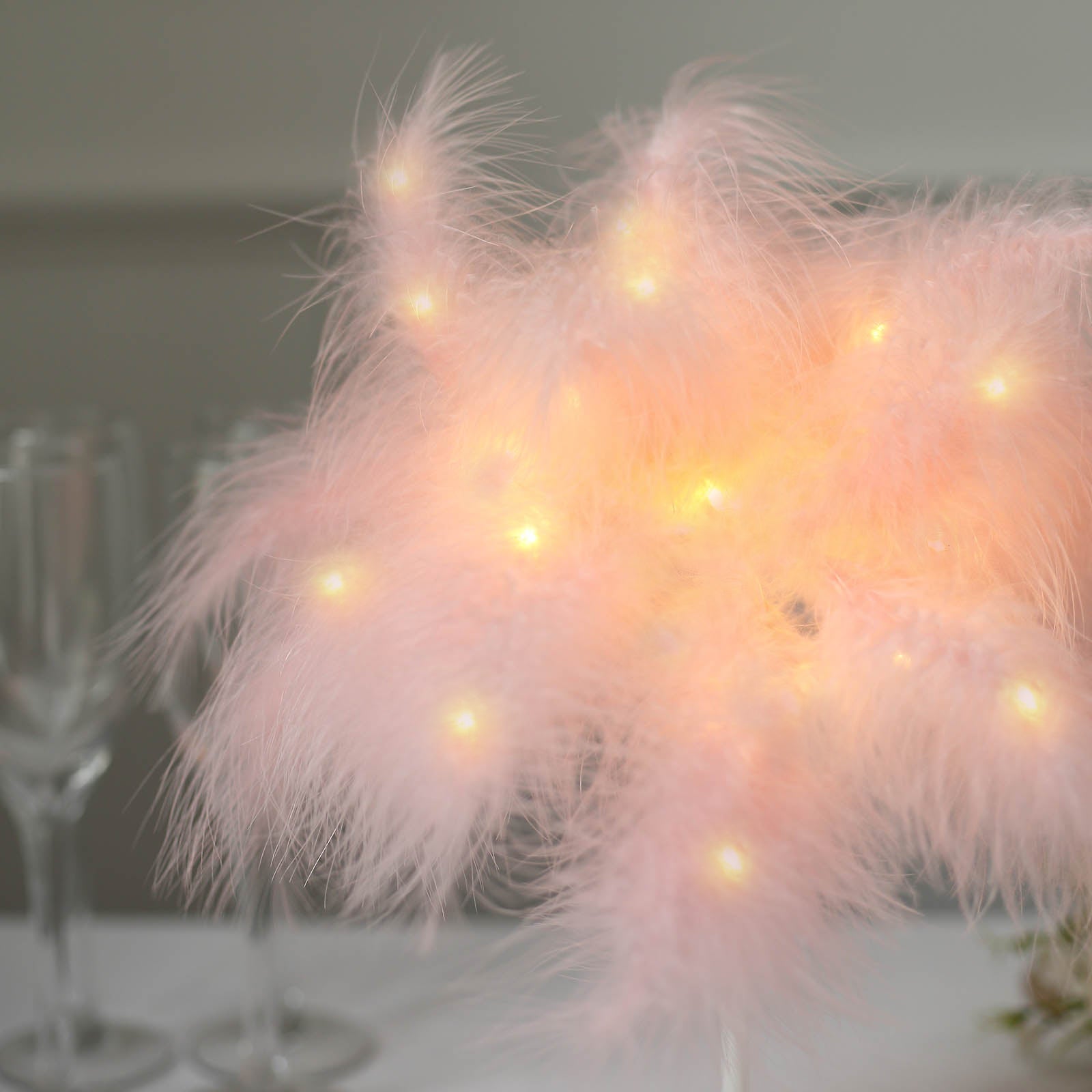 Pink LED blush feather lamp centerpiece for weddings.