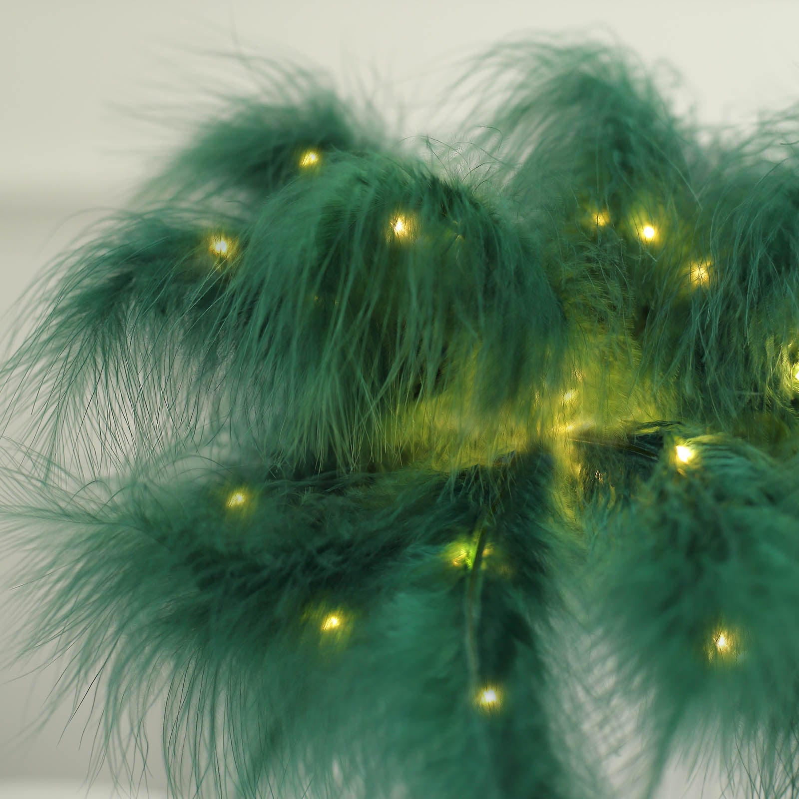 Emerald green feather table lamp with warm LED lights.