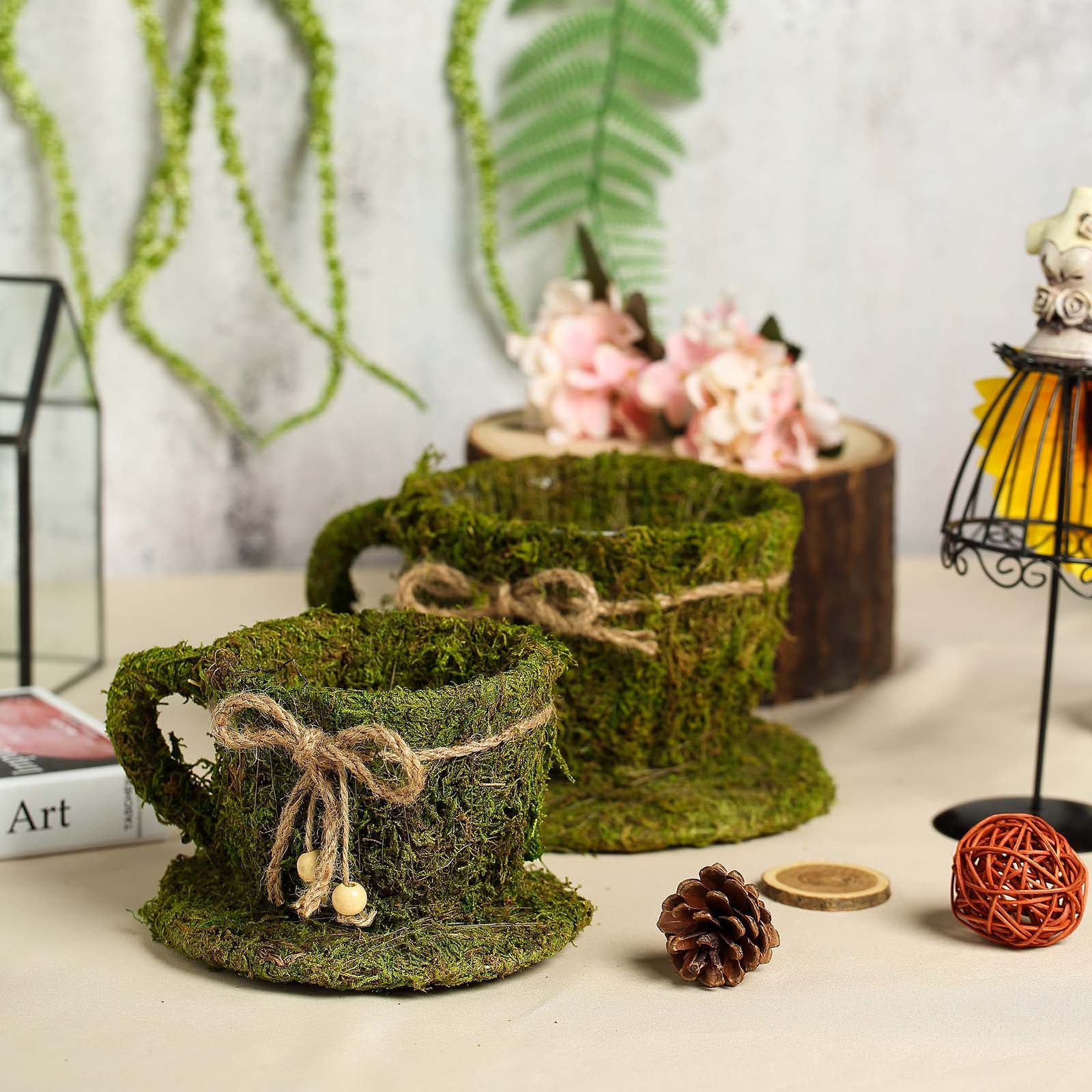 Green teacup planters with preserved moss and twine, perfect for floral displays.