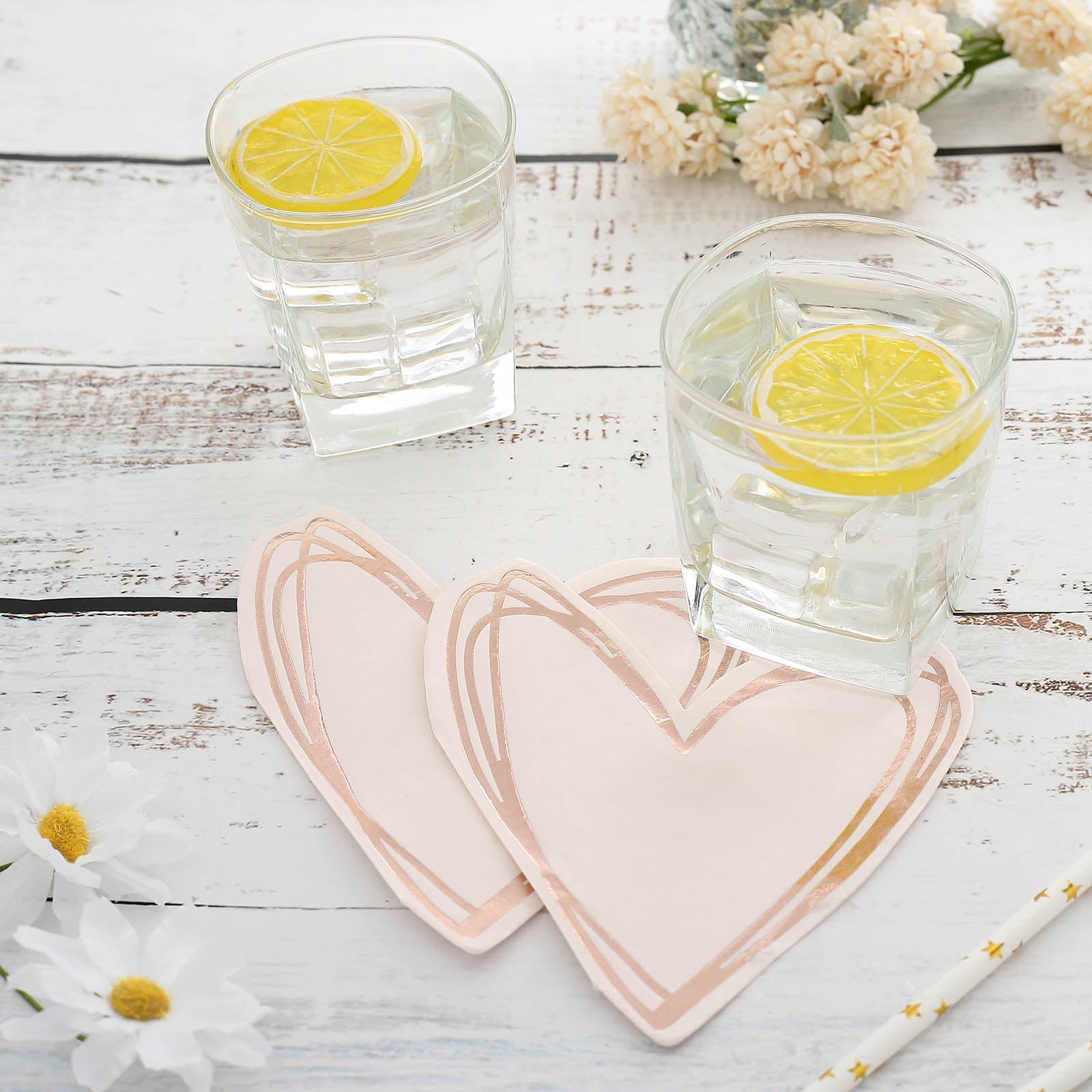 Rose gold heart-shaped disposable cocktail napkins on a table.