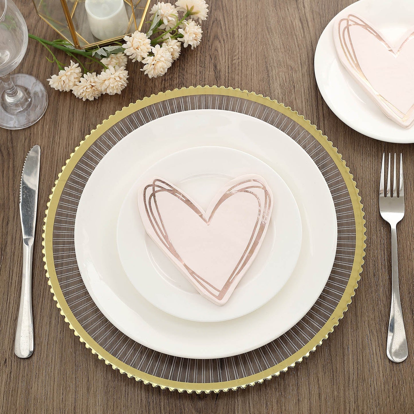 Rose gold heart-shaped disposable cocktail napkins on a plate.