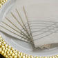 White linen-feel cocktail napkins with silver waves print on a plate.