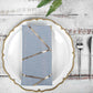 Modern dusty blue and geometric gold cloth dinner napkin on a decorative plate.