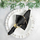 Modern black and gold geometric cloth dinner napkin on a white plate.