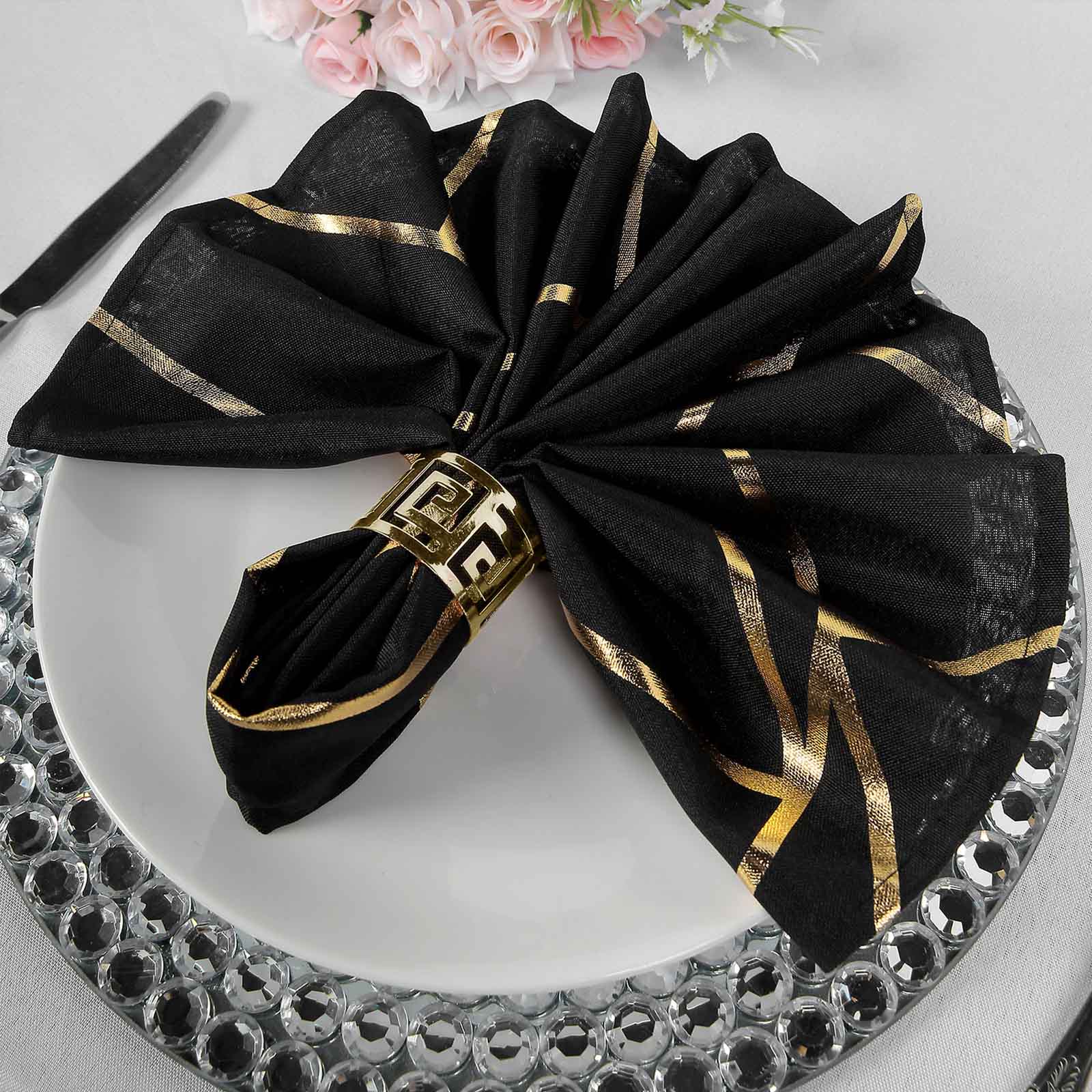 Black and gold geometric cloth dinner napkin set on a plate.