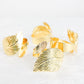 Metallic gold ornate leaf napkin rings, elegant linen napkin holders.