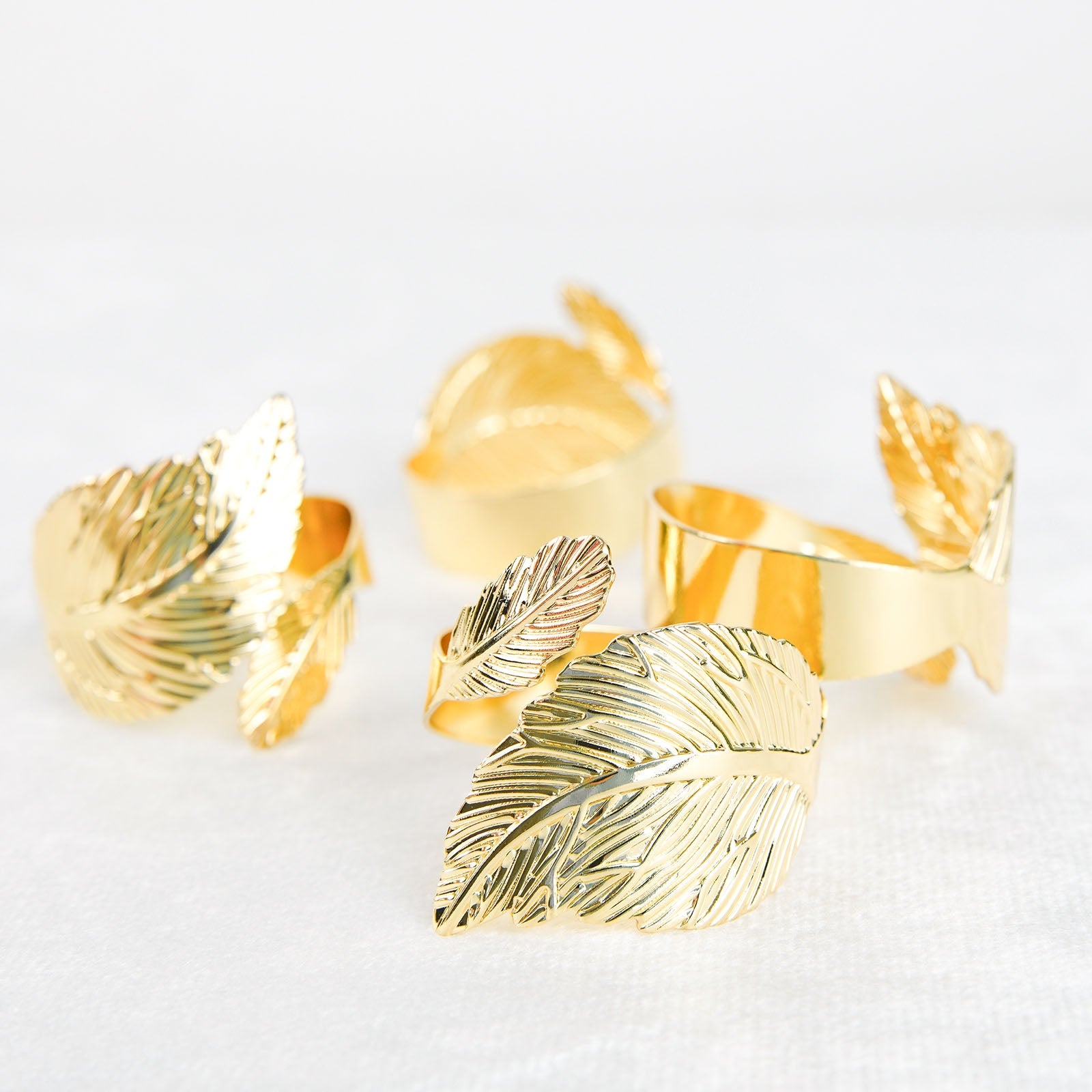 Metallic gold ornate leaf napkin rings, elegant linen napkin holders.