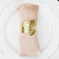 Metallic gold ornate leaf napkin ring on a linen napkin.