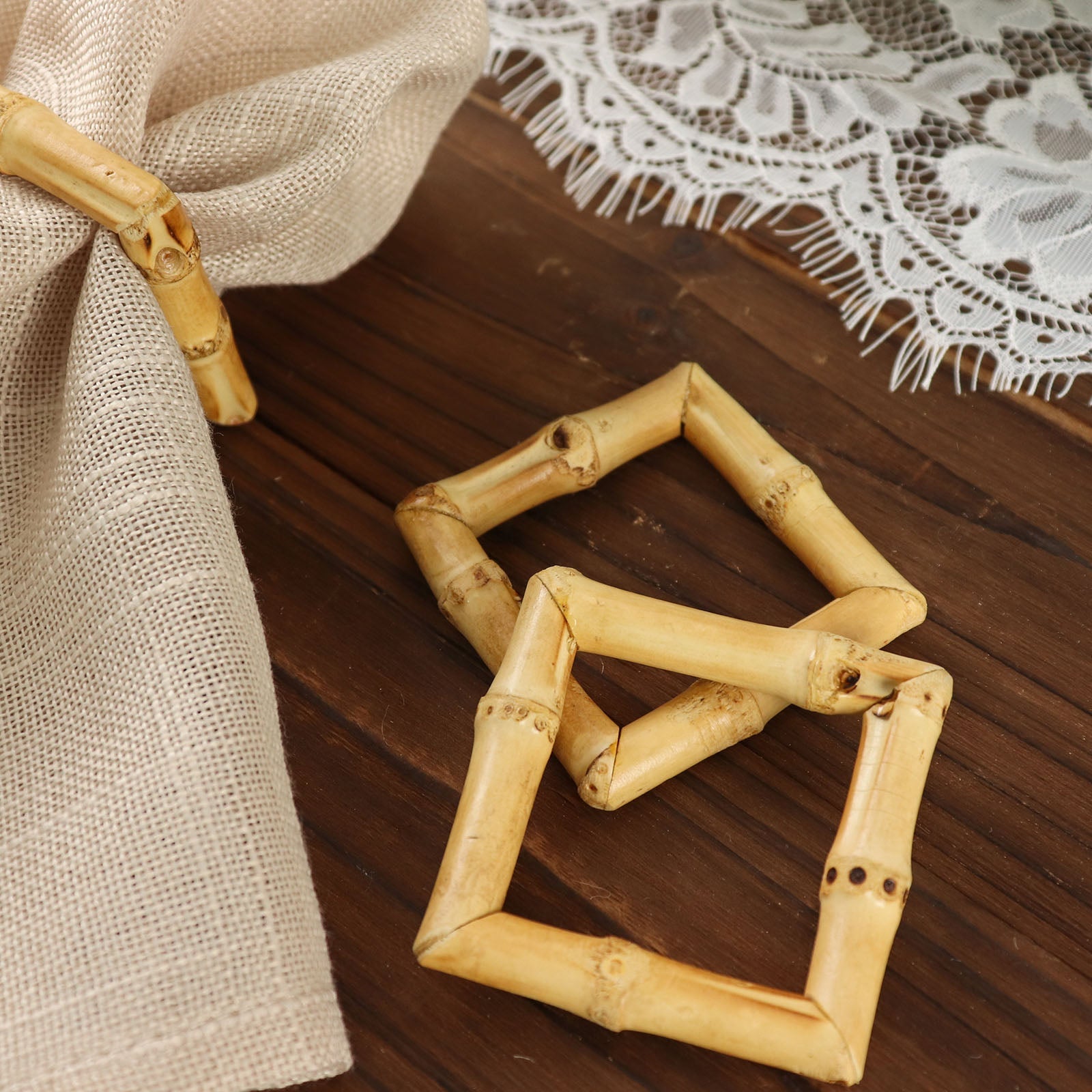 Natural bamboo square napkin rings on a rustic wooden surface.