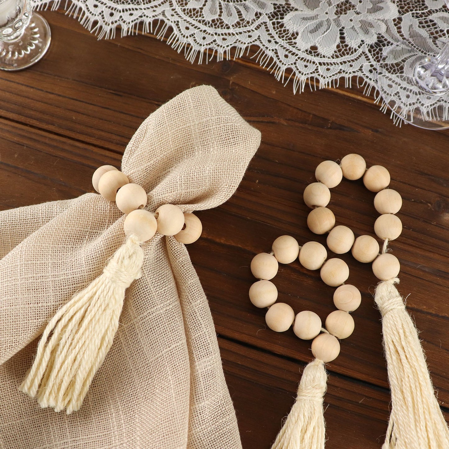 Cream wooden bead napkin rings with tassels, rustic farmhouse style.