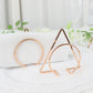 Gold geometric metal napkin rings on a white table setting.