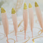 Blush feathers with glitter gold tips for party decoration.