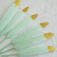 Mint green feathers with glitter gold tips for craft decorations.
