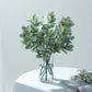 Frosted green artificial lambs ear leaf indoor plant arrangement in a glass vase.