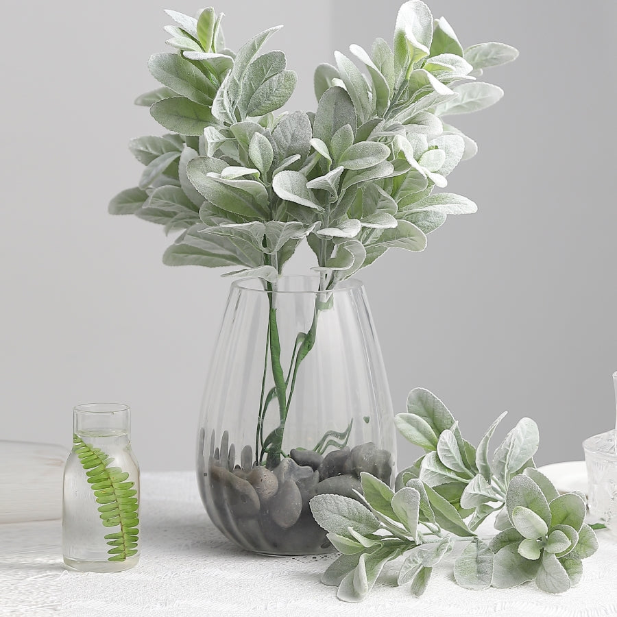 Frosted green artificial lambs ear leaves in a glass vase.
