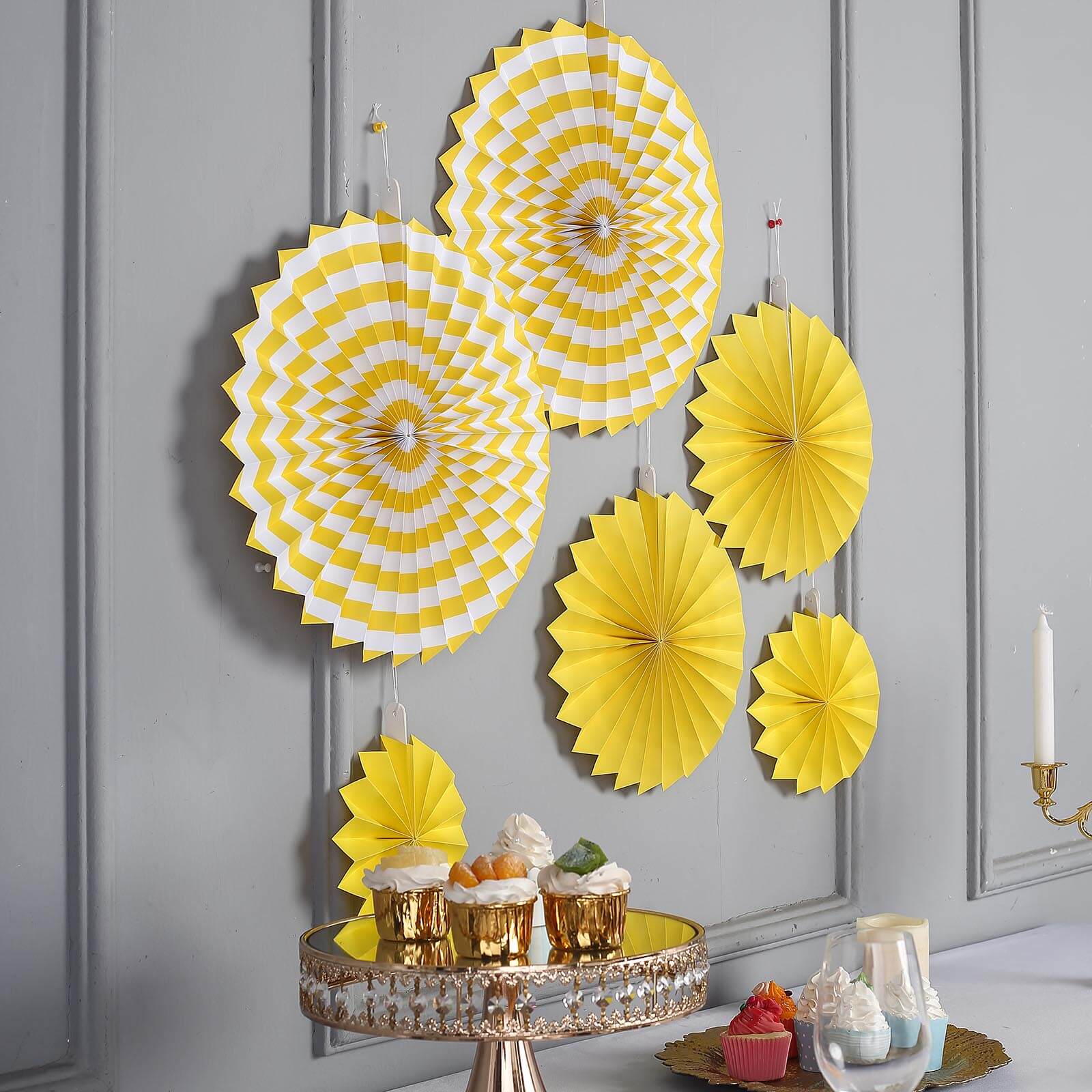 Yellow hanging paper fan decorations set, perfect for party backdrops.