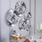 Metallic silver hanging paper fan decorations in a stylish wall backdrop.