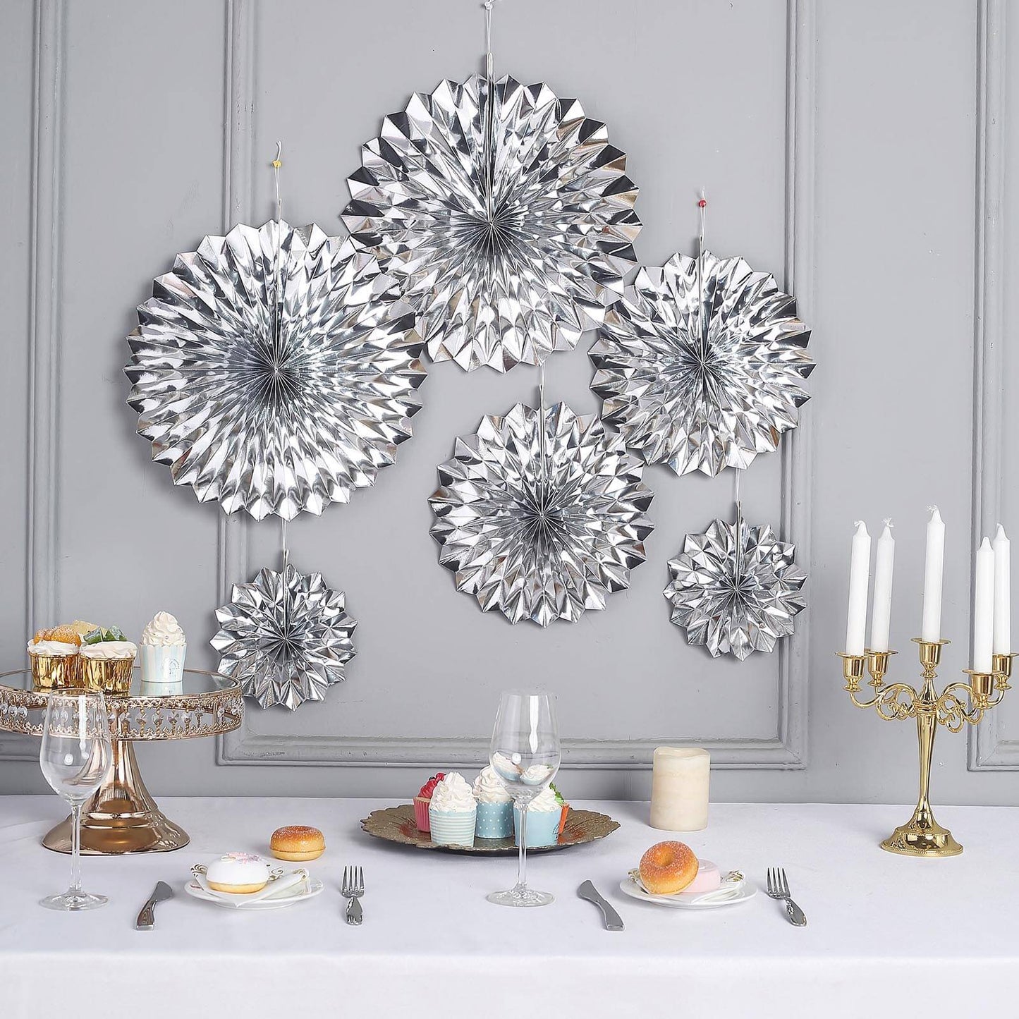 Metallic silver hanging paper fan decorations for party backdrop.