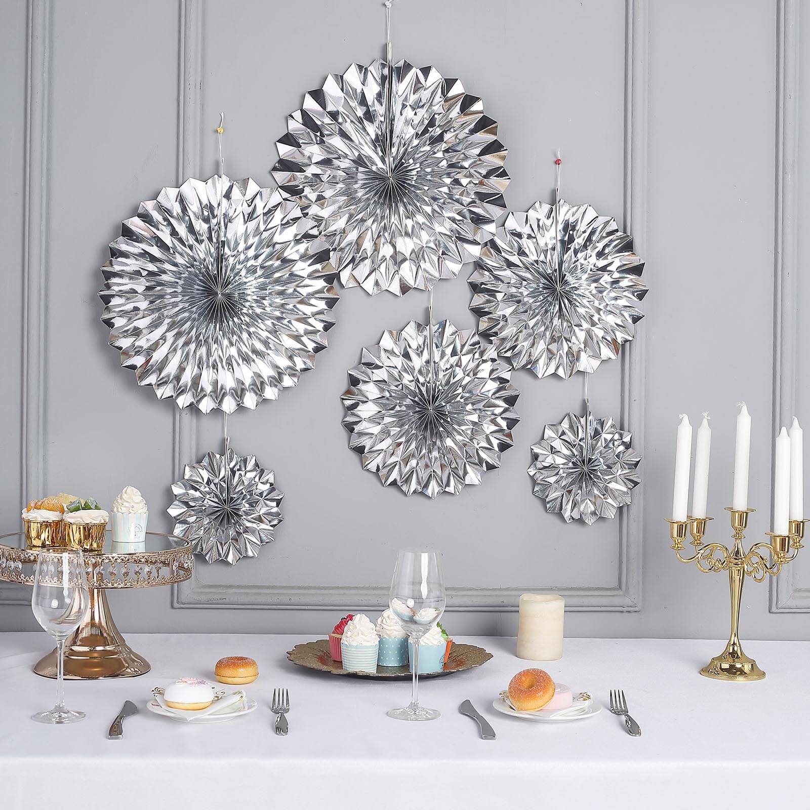 Metallic silver hanging paper fan decorations for party backdrop.