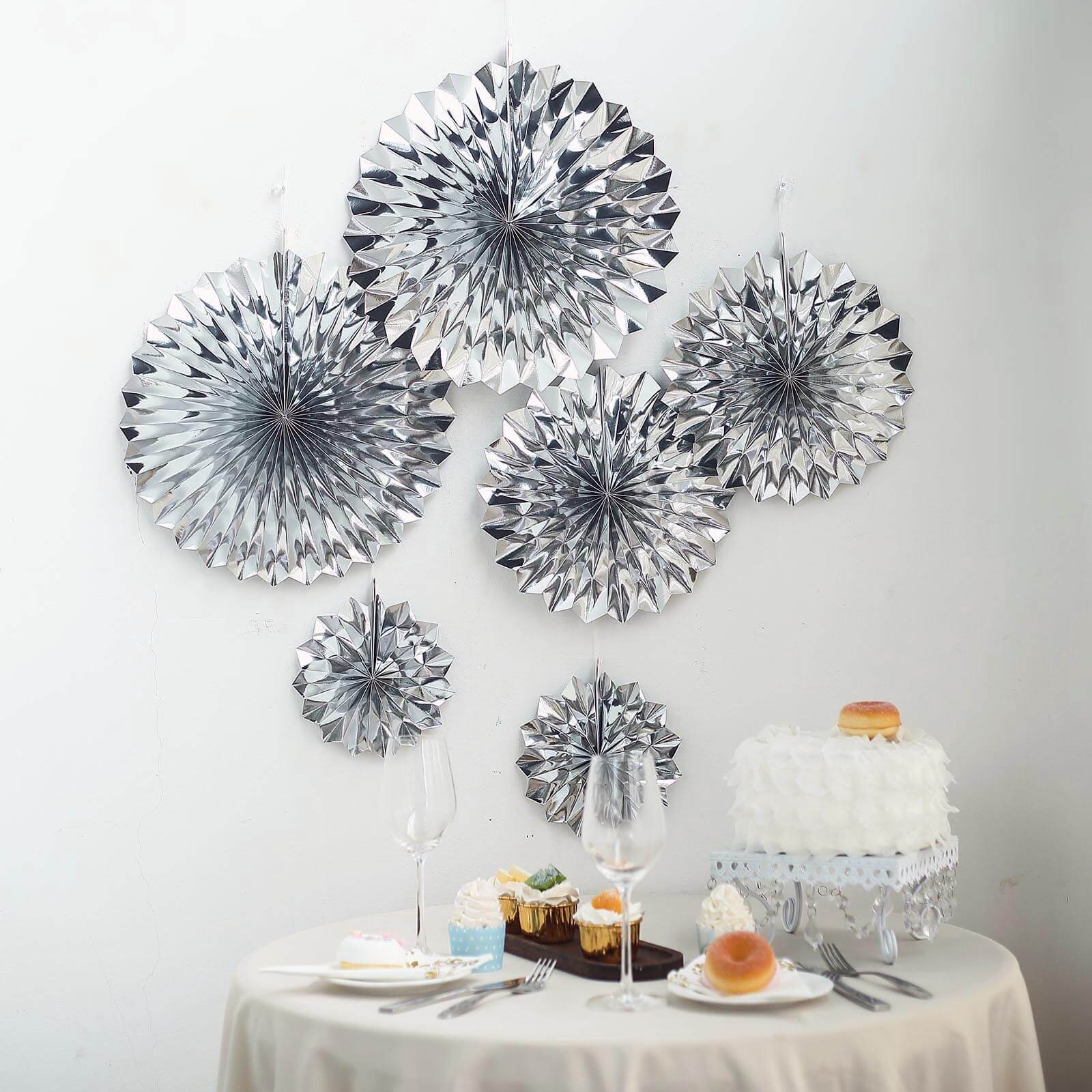 Metallic silver hanging paper fan decorations for party backdrop.
