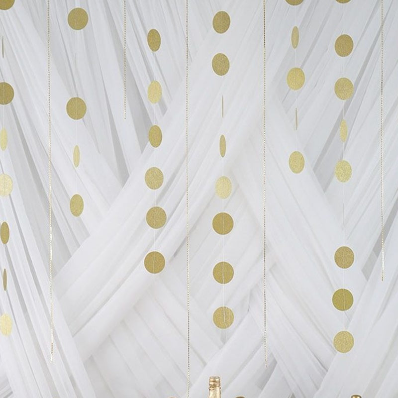 Gold circle dot party paper garland banner on a white backdrop.