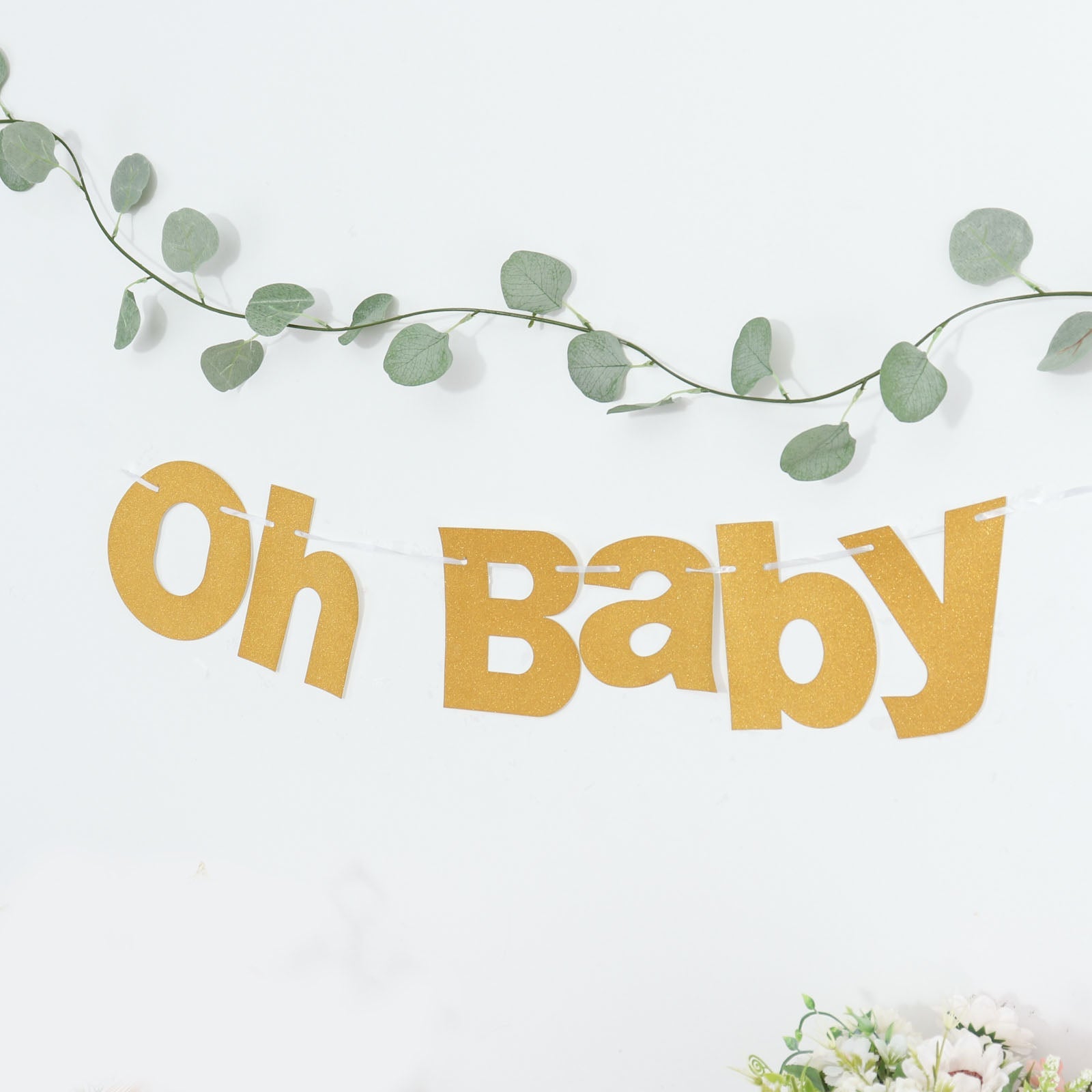 Gold glittered "Oh Baby" garland banner for baby shower decoration.