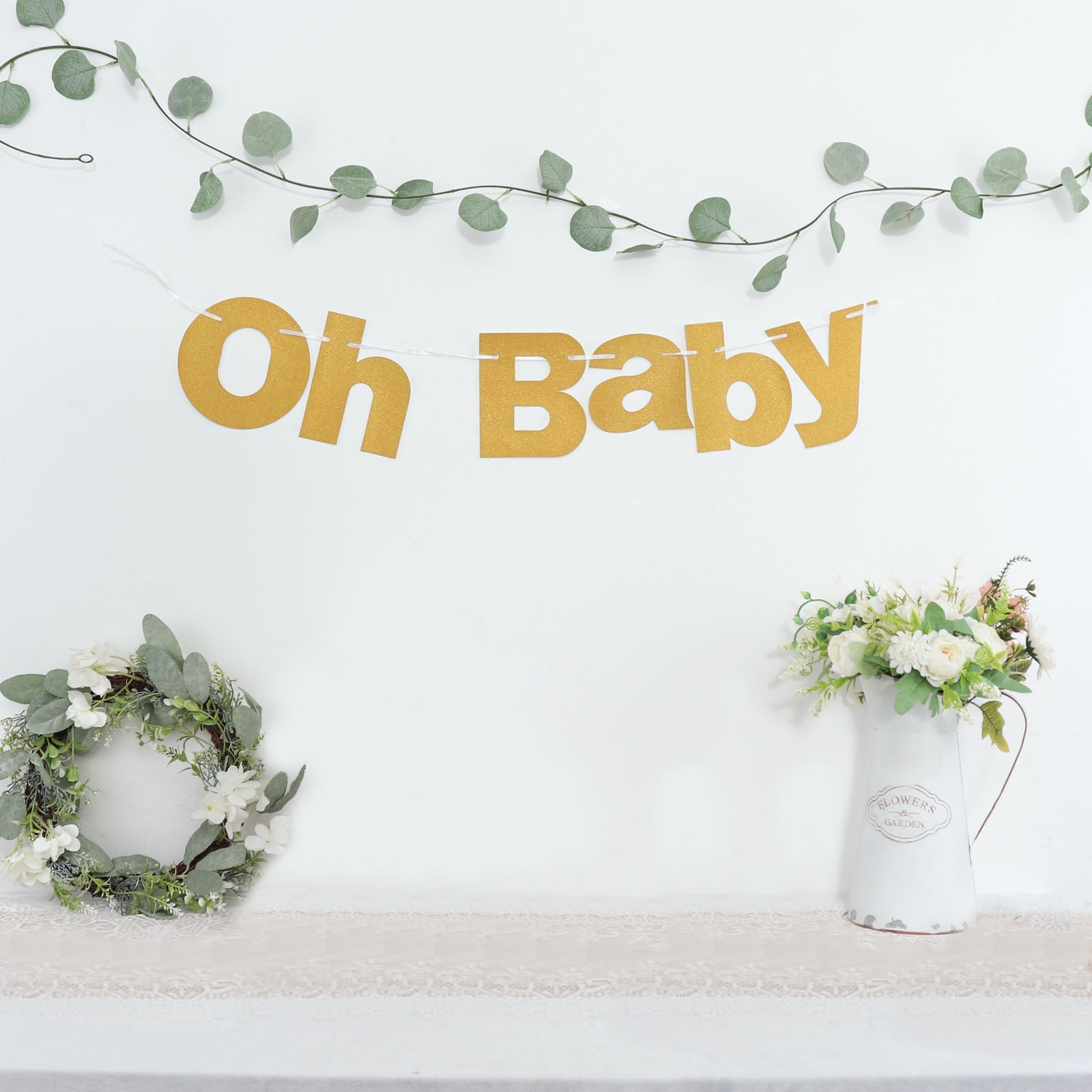 Gold glittered "Oh Baby" garland banner for baby shower decoration.