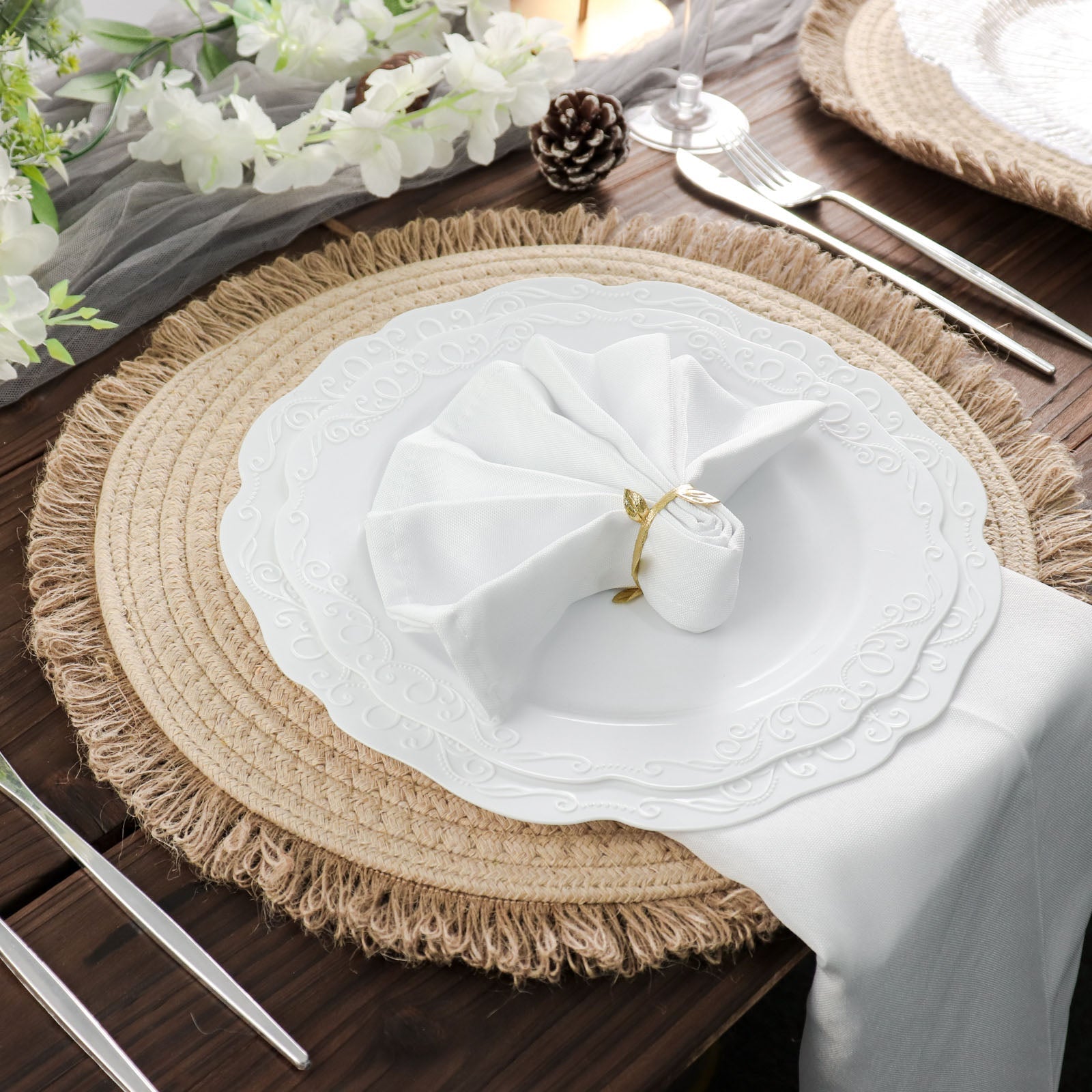 Natural burlap round placemats with fringed edges on a wooden table.