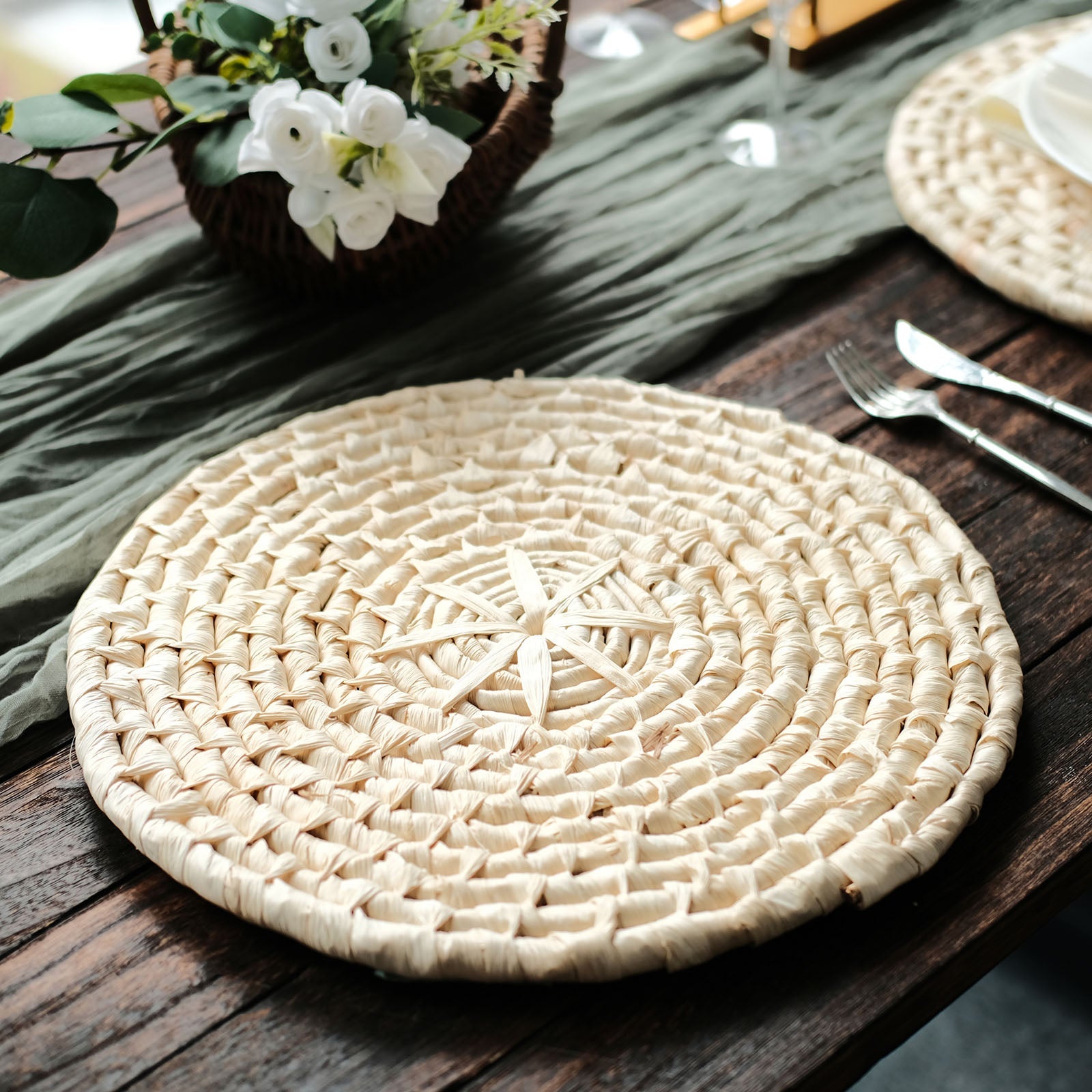 Natural corn husk round woven placemat on a rustic wooden table.