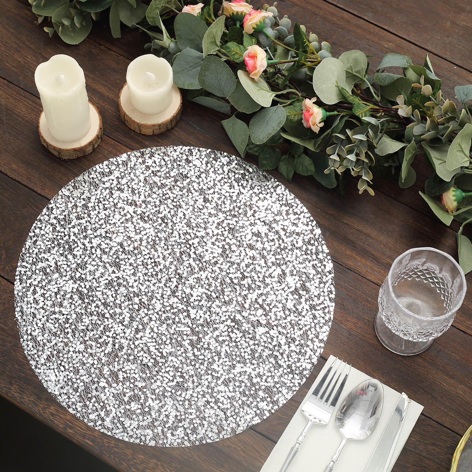 Metallic silver round sequin placemat on a wooden dining table.