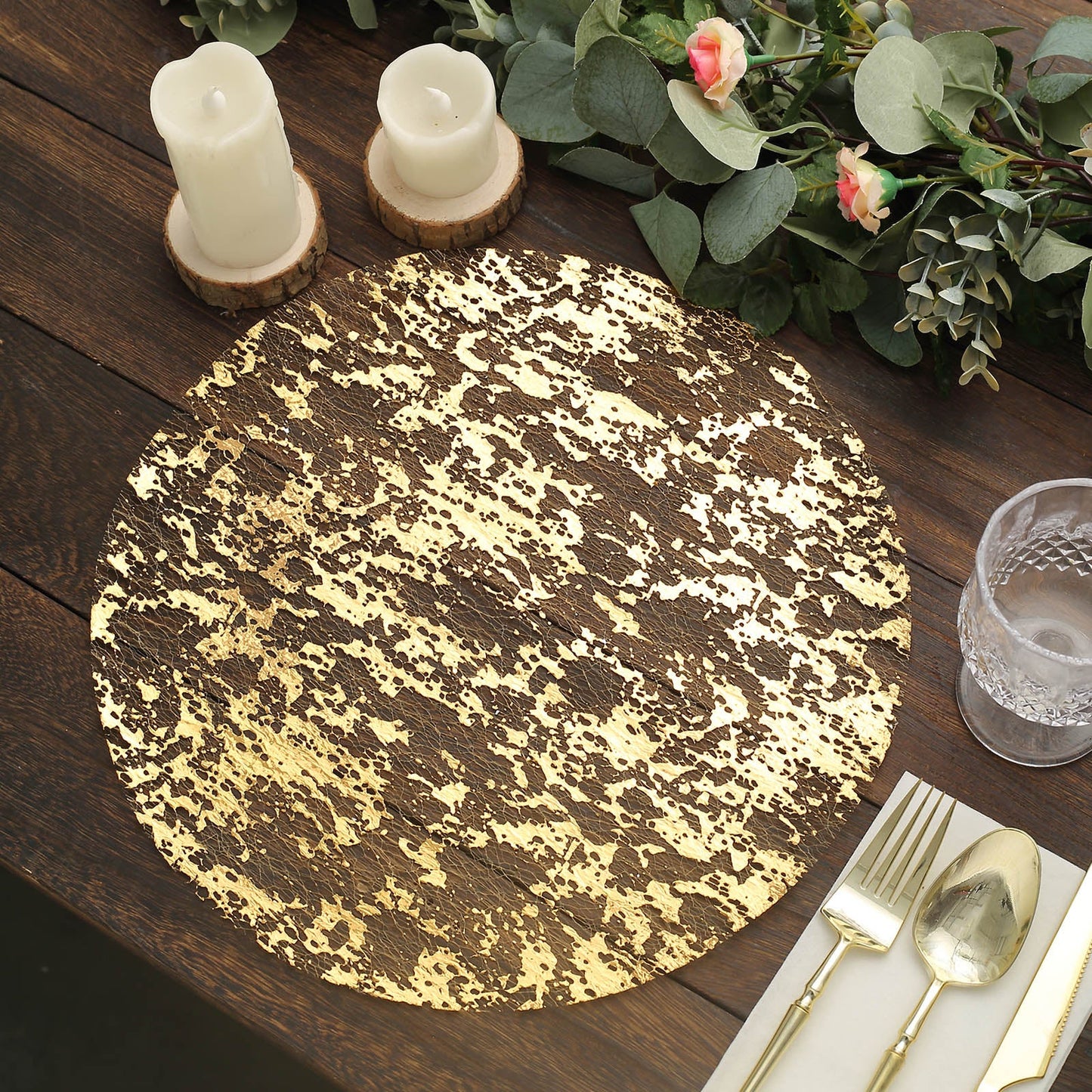 Metallic gold foil round disposable table placemat on a wooden table.