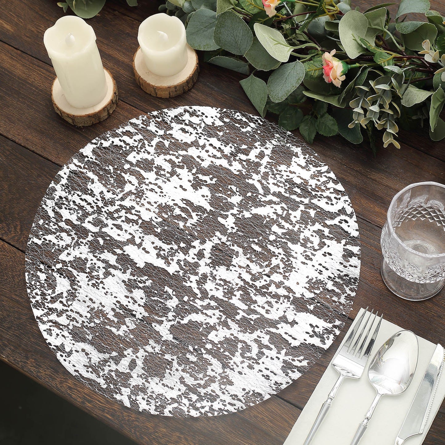 Metallic silver foil round disposable table placemat on a rustic wooden table.