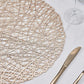 Champagne metallic round placemat on a white table setting.