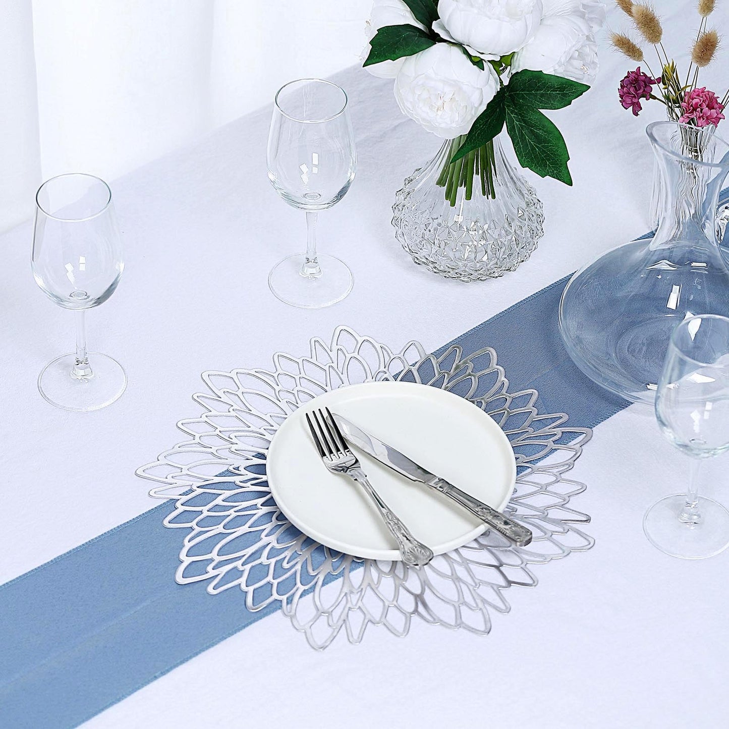 Silver vinyl placemats with floral design on a dining table setting.