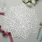 Silver floral vinyl placemat on dining table with decorative elements.