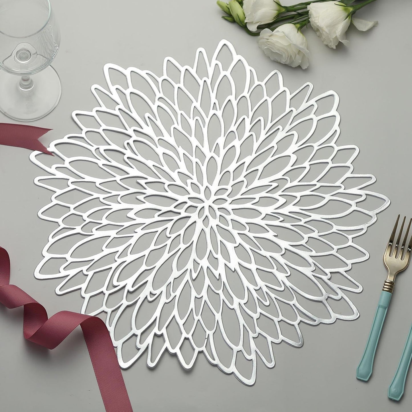 Silver floral vinyl placemat on dining table with decorative elements.