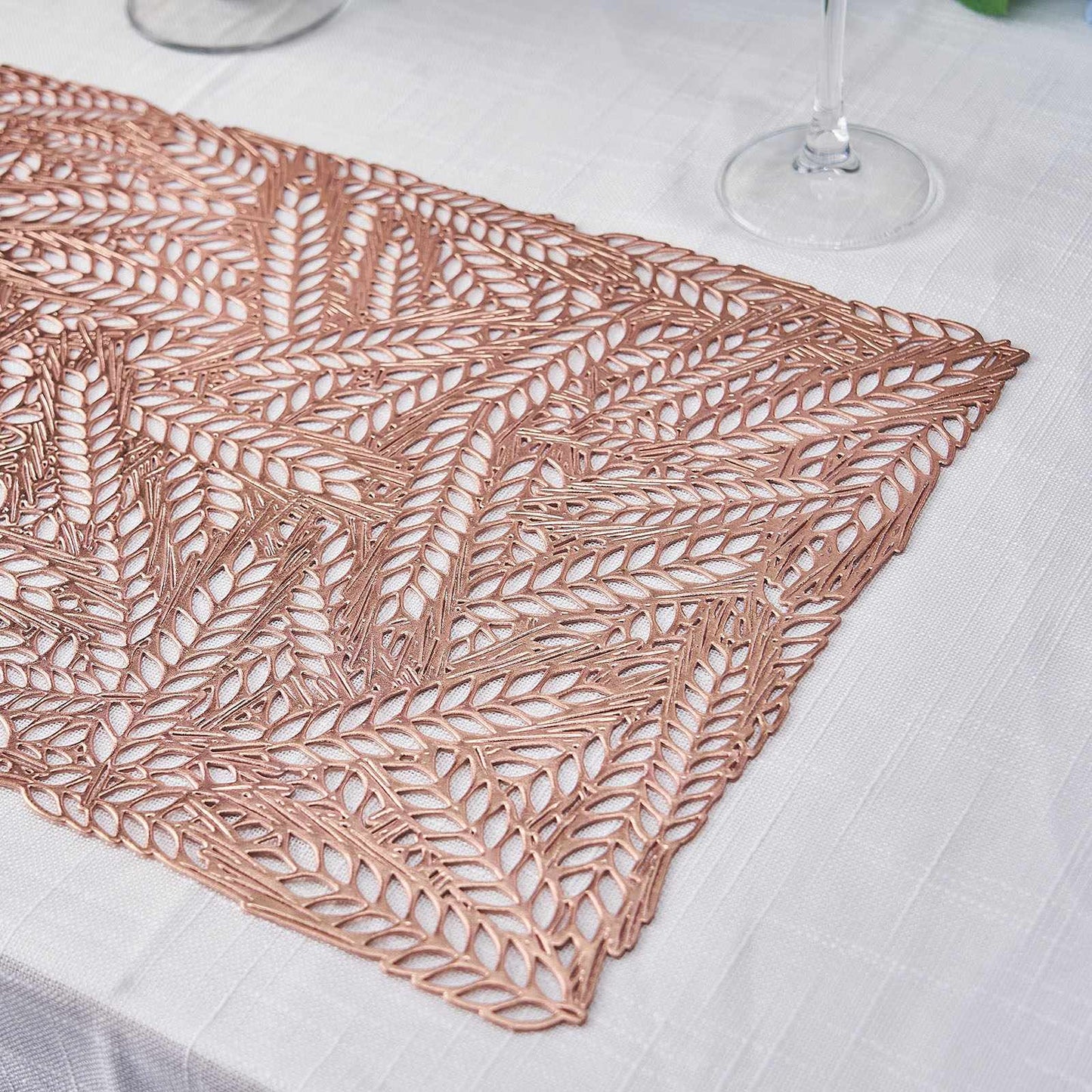 Rose gold vinyl placemat with a metallic wheat design on a table setting.