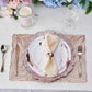Rose gold vinyl placemats with metallic wheat design on a dining table setting.
