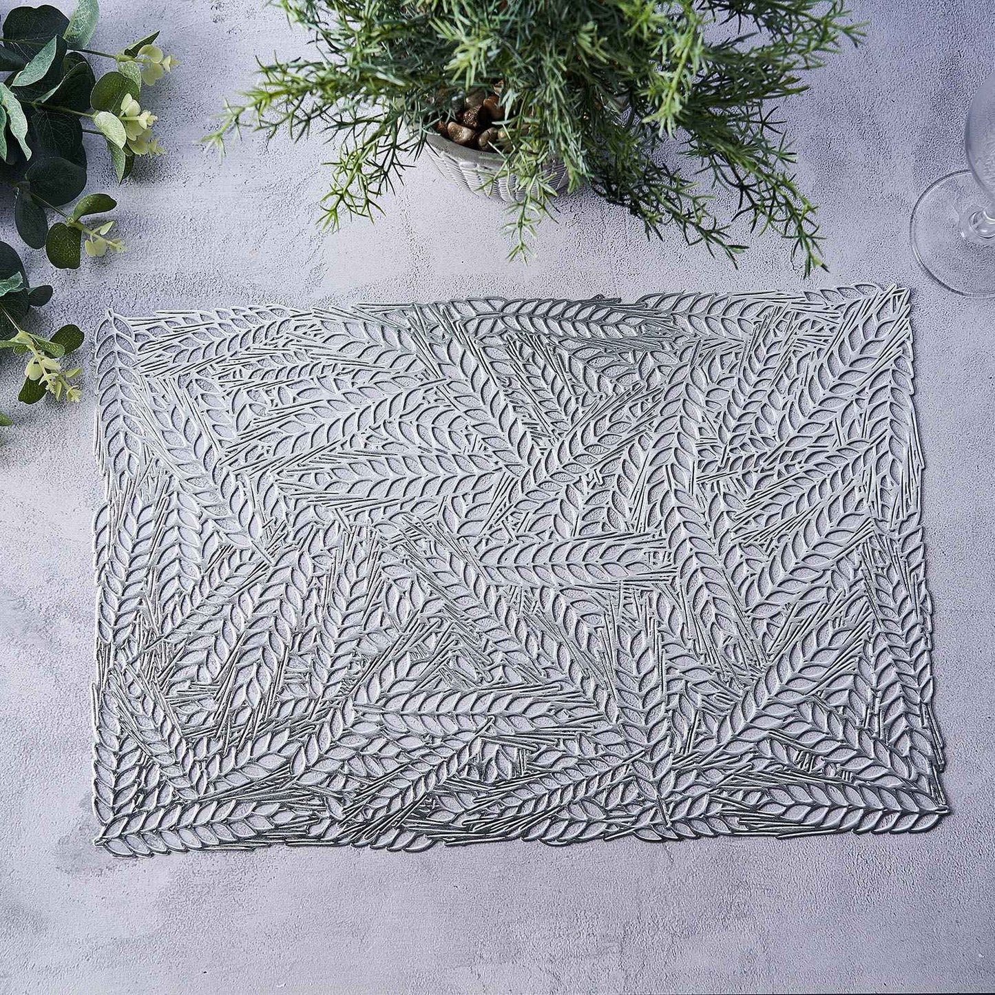 Silver metallic placemat with wheat design on a light surface.