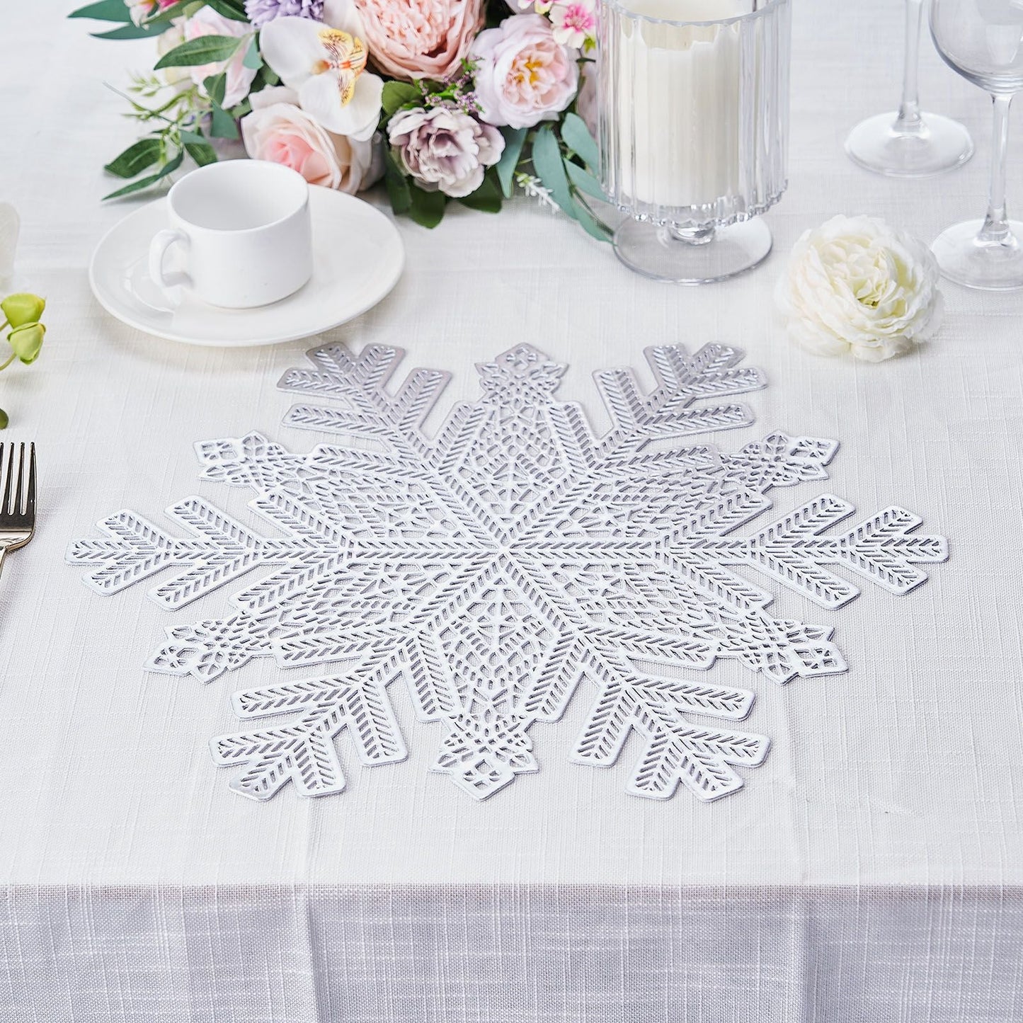 Silver metallic snowflake vinyl placemat on a winter-themed table setting.