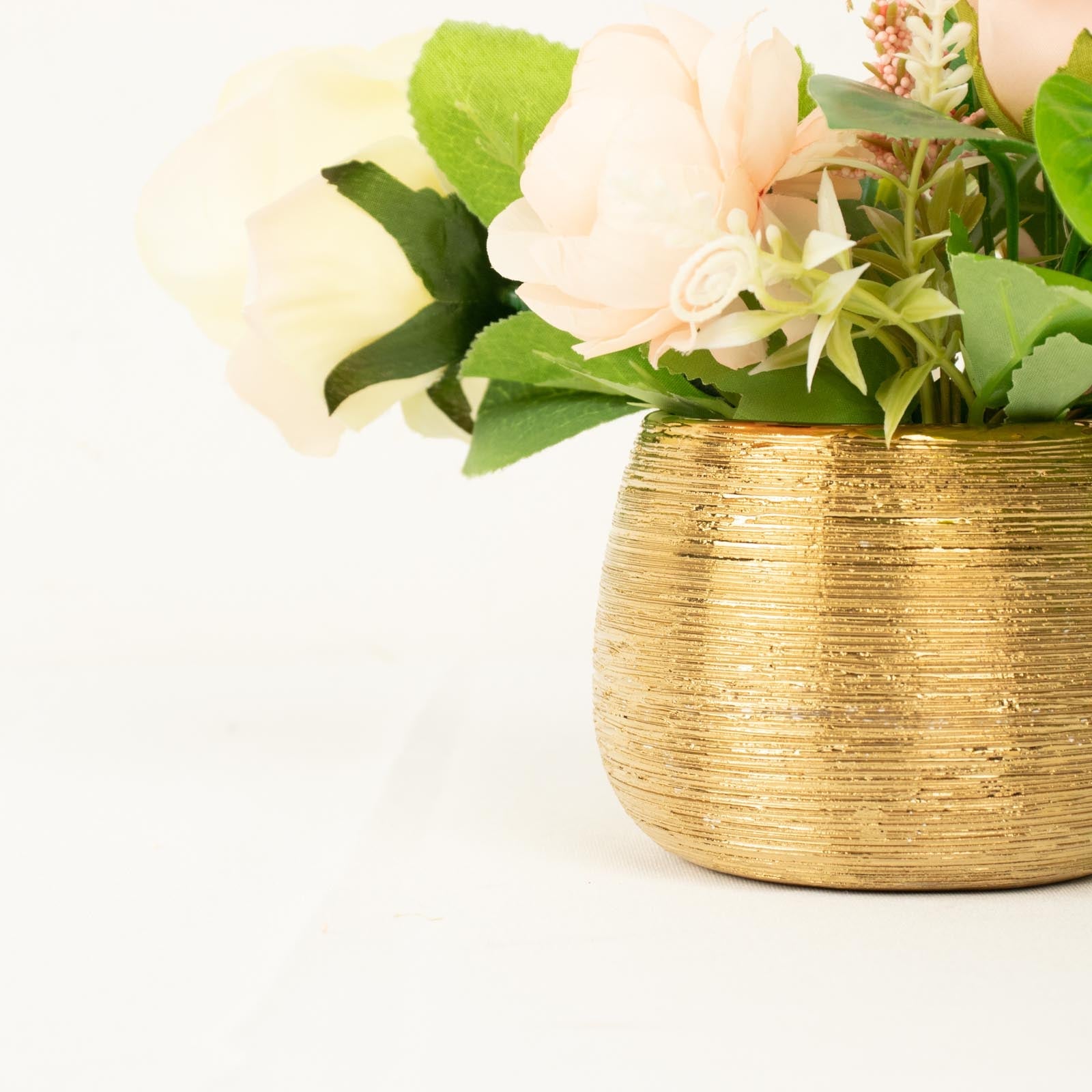 Gold textured ceramic flower vase with pink flowers, perfect for indoor décor.