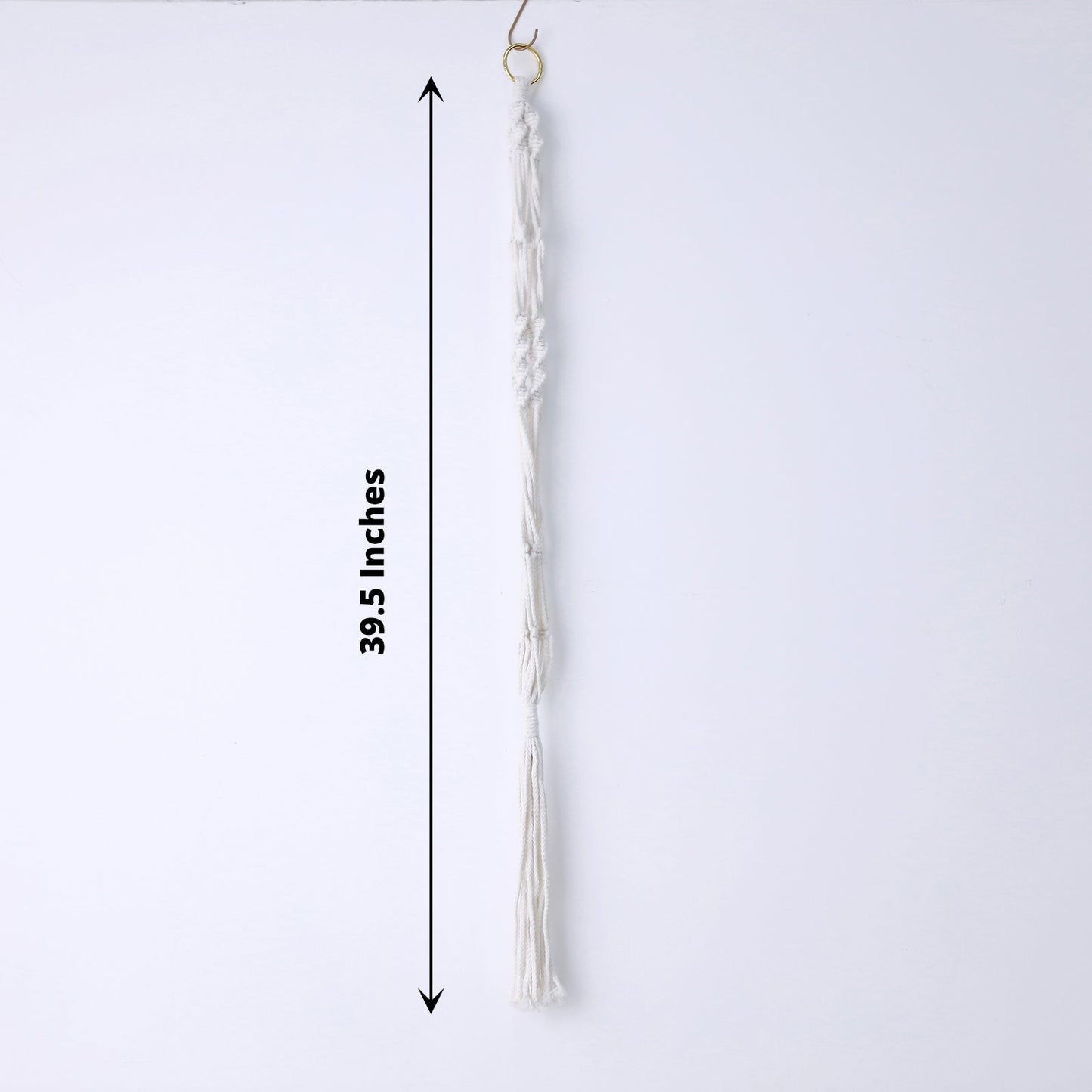 Ivory macrame hanging planter basket with tassel for boho chic decor.