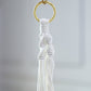 Ivory macrame hanging planter basket with tassel for boho chic decor.