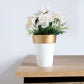 White gold rimmed medium flower pot with faux flowers.