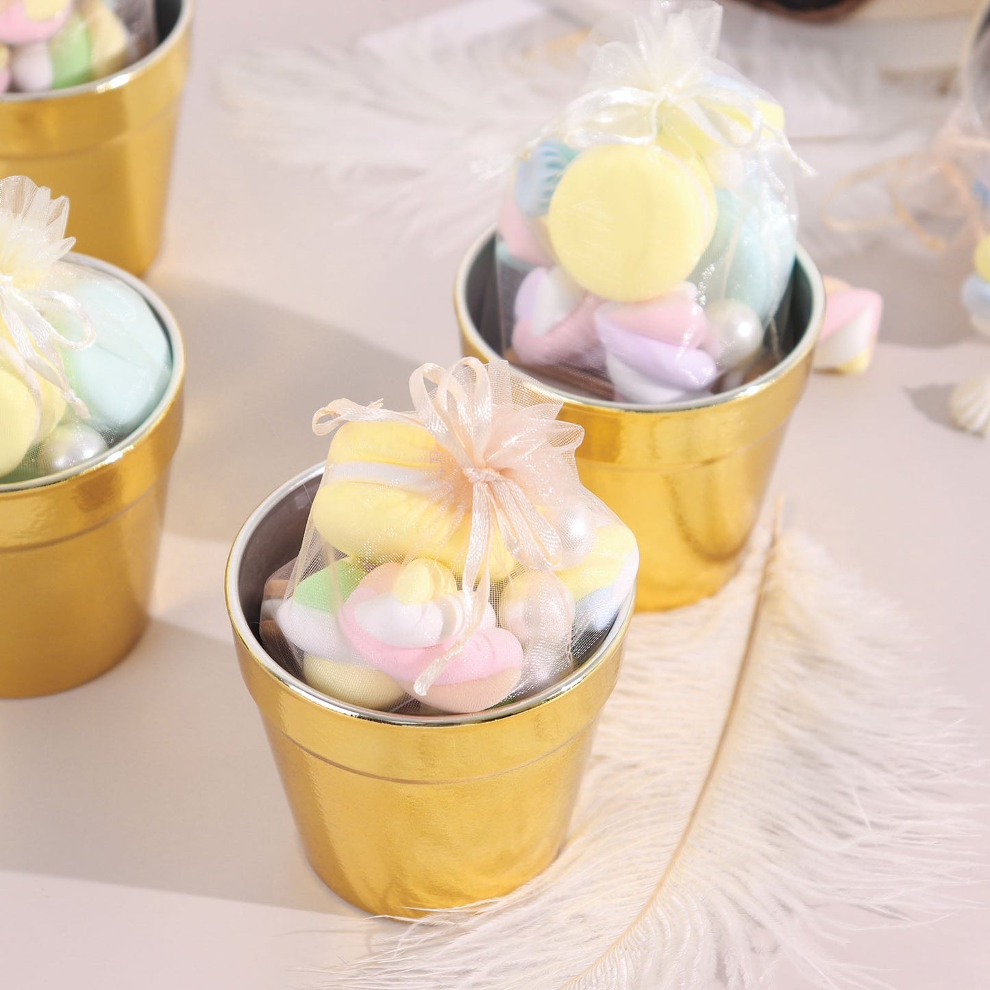 Gold mini party favor buckets filled with colorful treats.