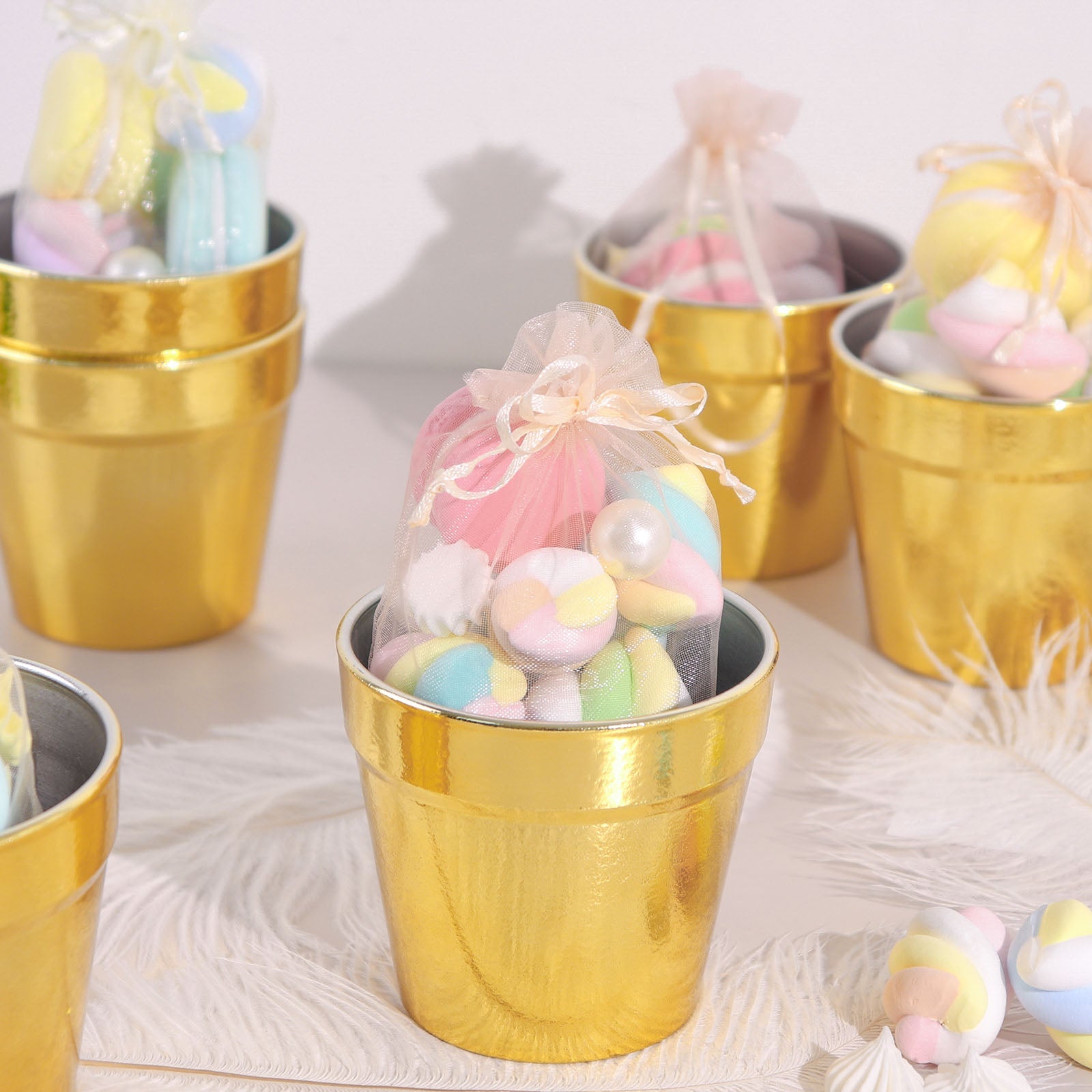 Gold mini party favor buckets filled with colorful treats.
