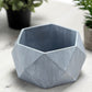 Gray finished concrete geometric planter for succulents.