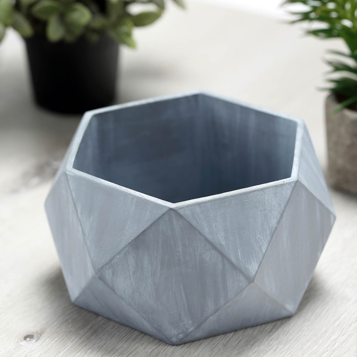 Gray finished concrete geometric planter for succulents.