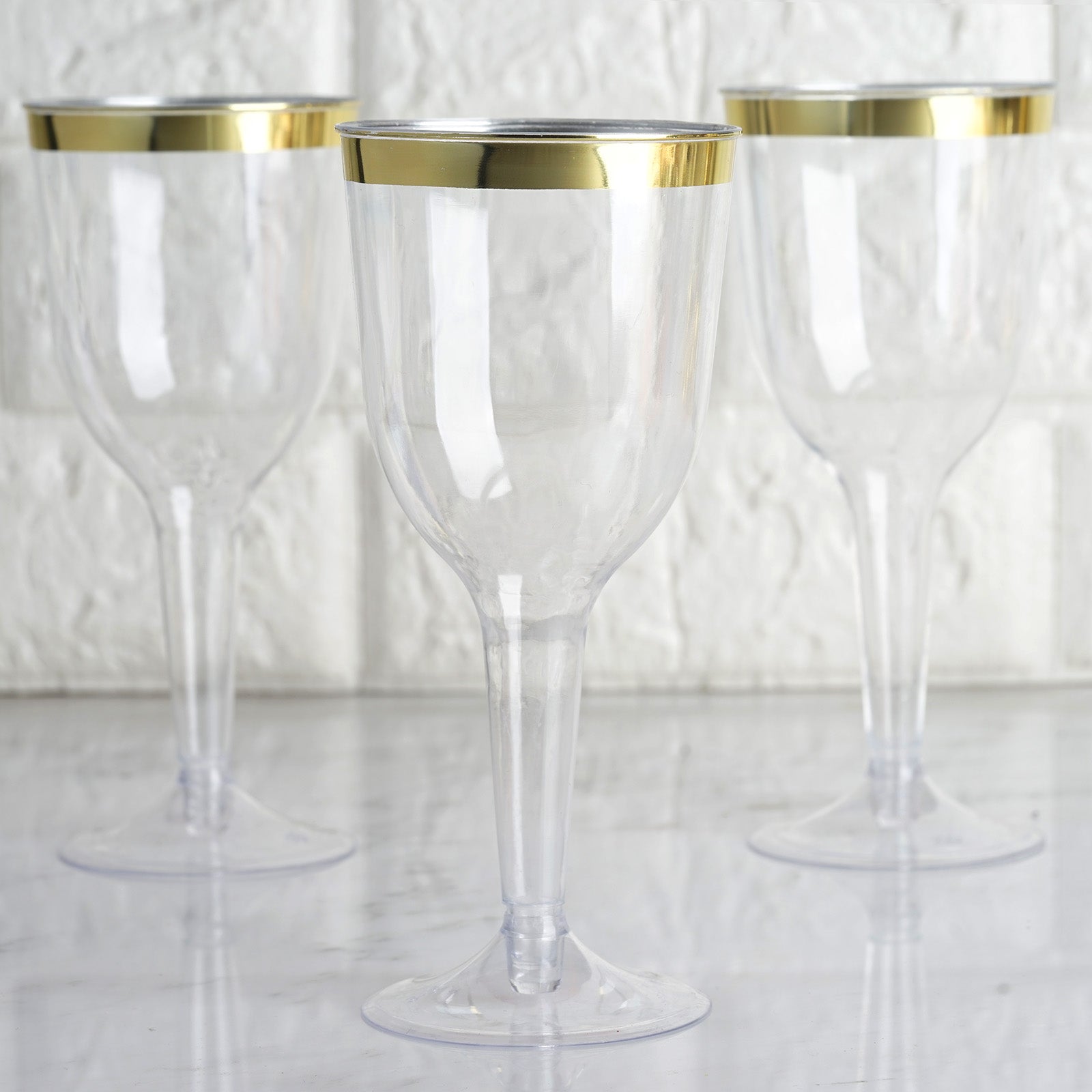 Clear plastic wine goblet glasses with gold rim, set of three.