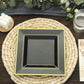 Gold trim black square disposable dinner plate on a woven placemat.